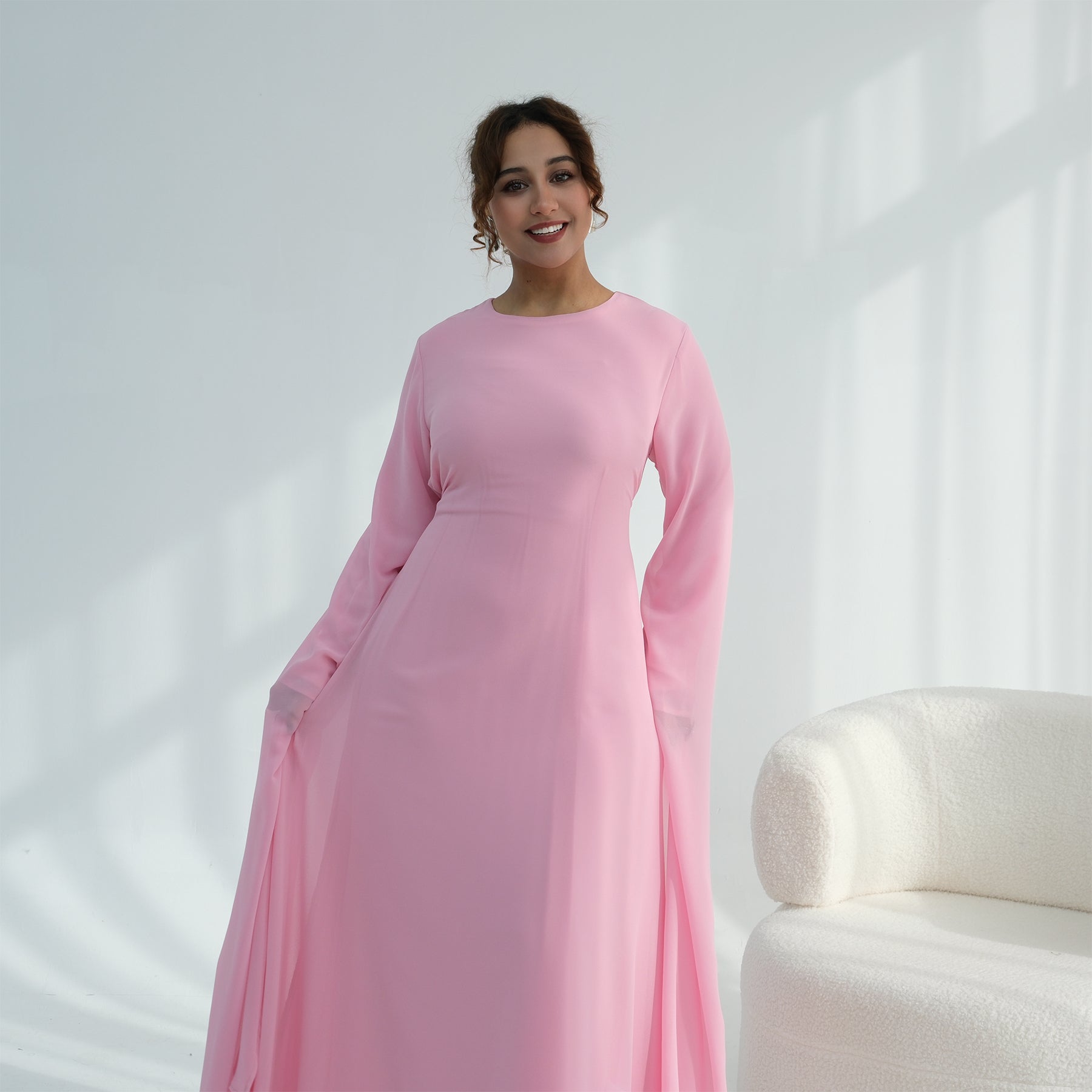 Woman wearing a pink dress against a white background