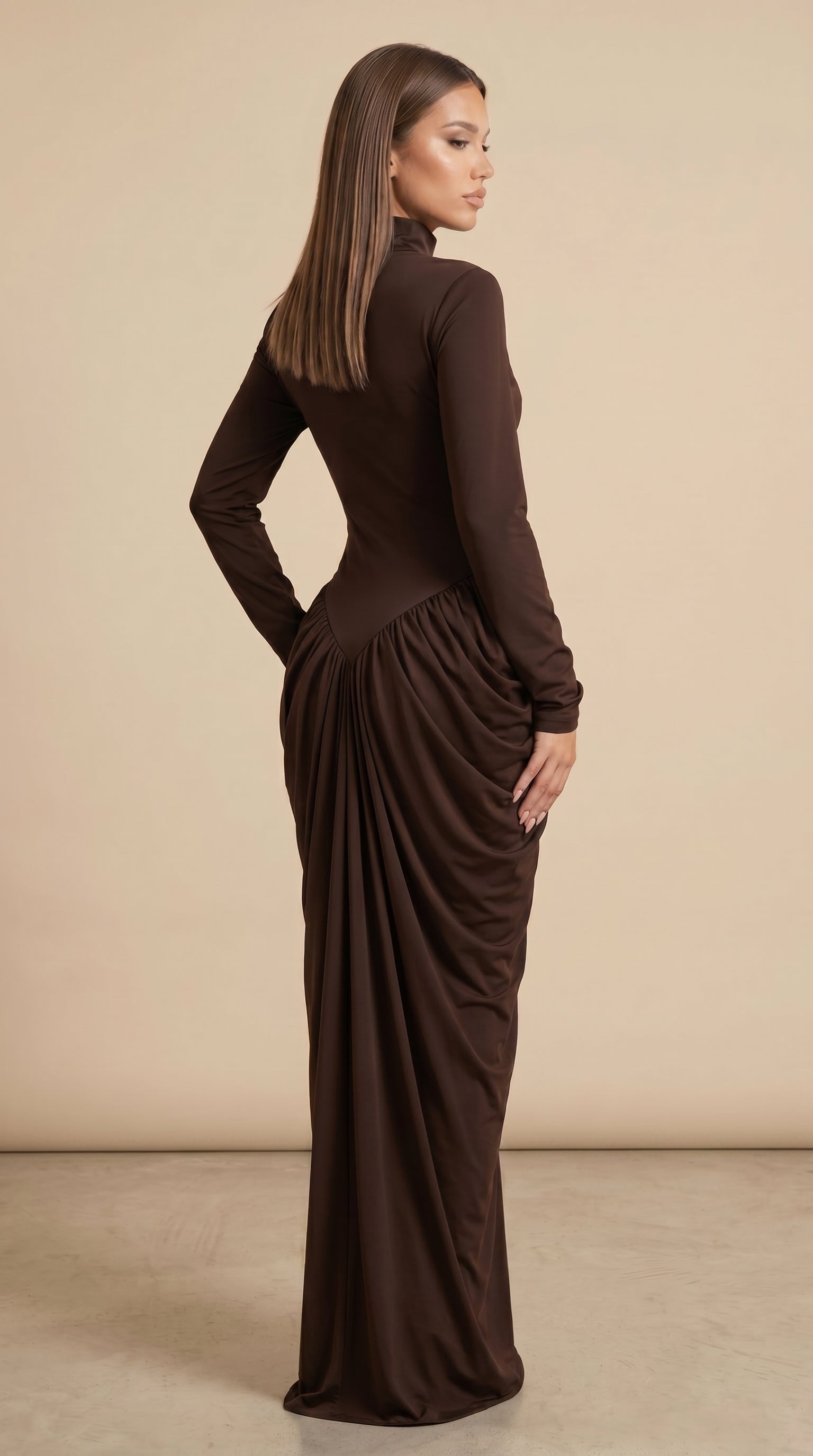 Woman wearing a brown long-sleeve dress with a draped effect on a beige background