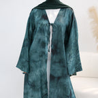 Teal tie-dye dress on a mannequin against a white background