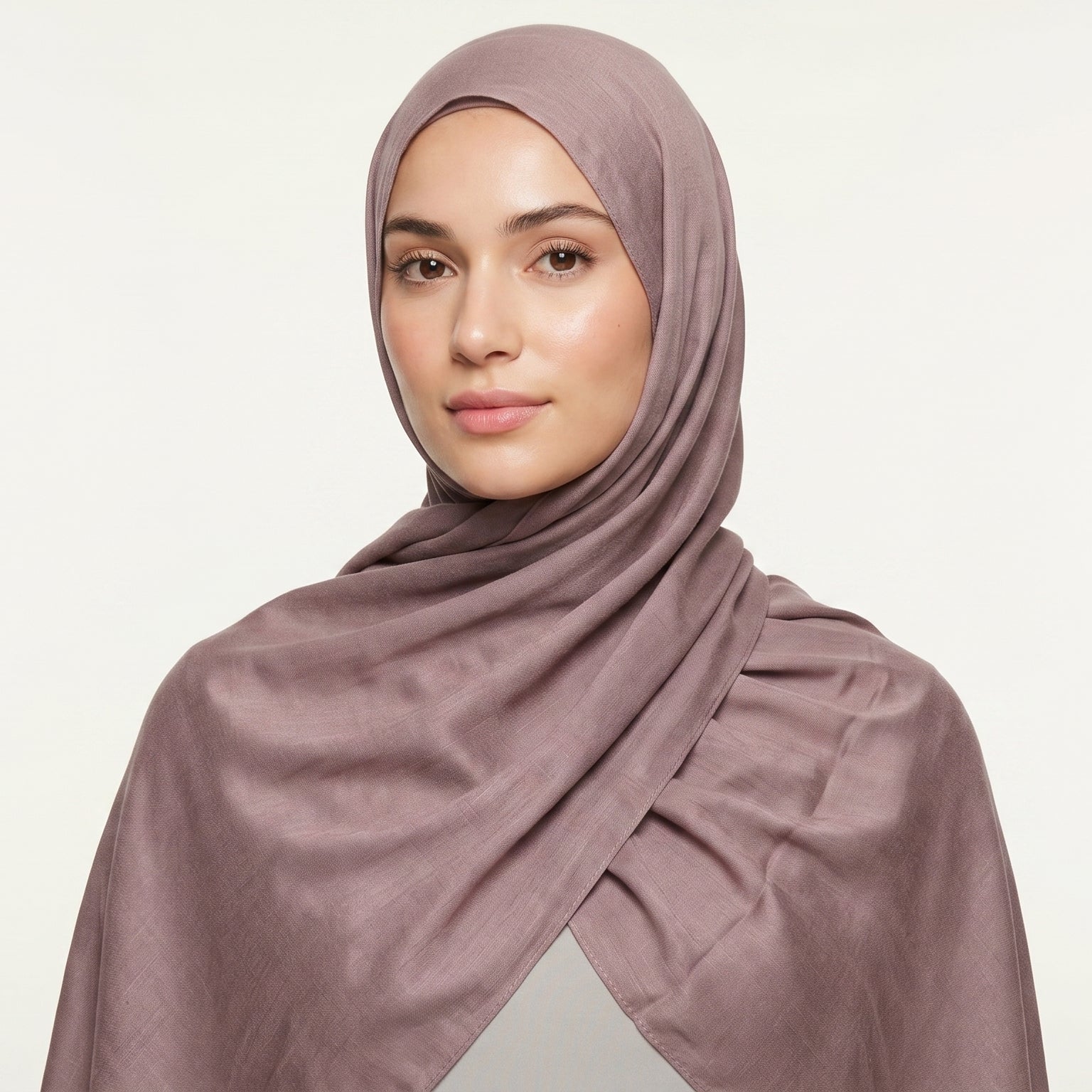 Woman wearing a mauve hijab against a light background