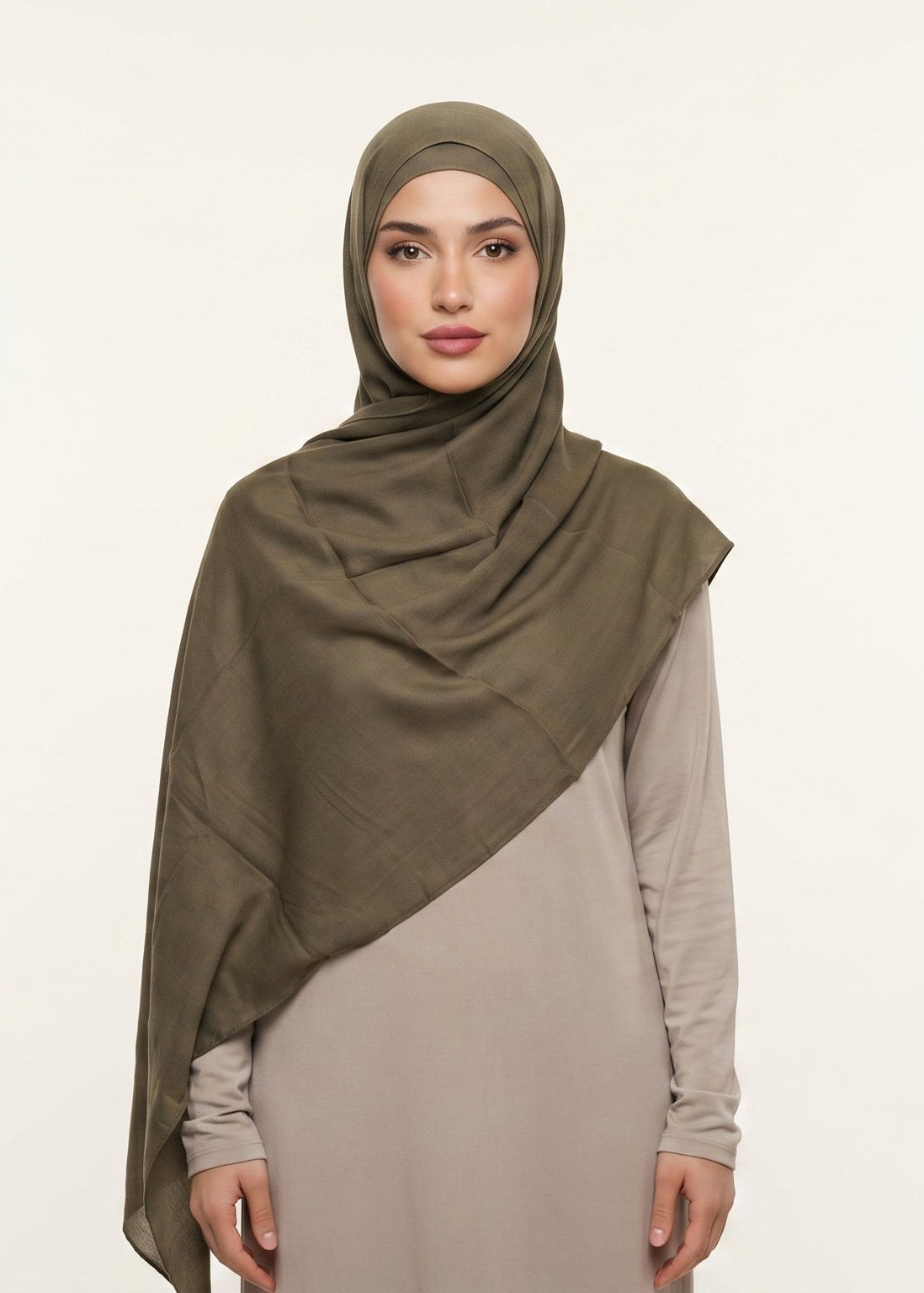 Woman wearing an olive hijab and beige dress on a white background