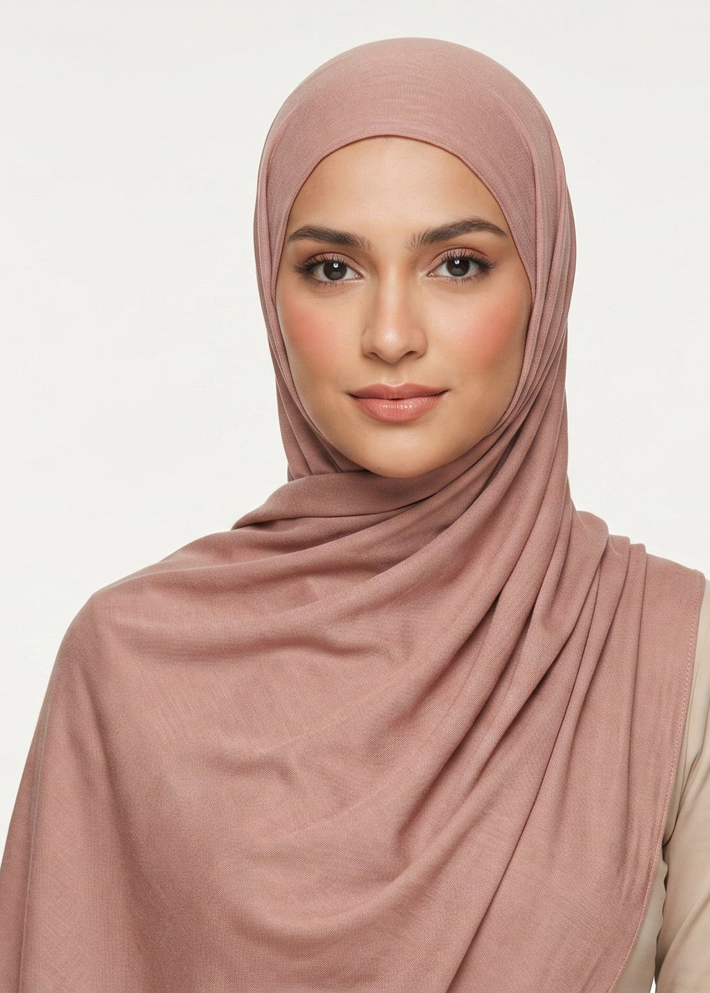 Woman wearing a pink hijab against a white background