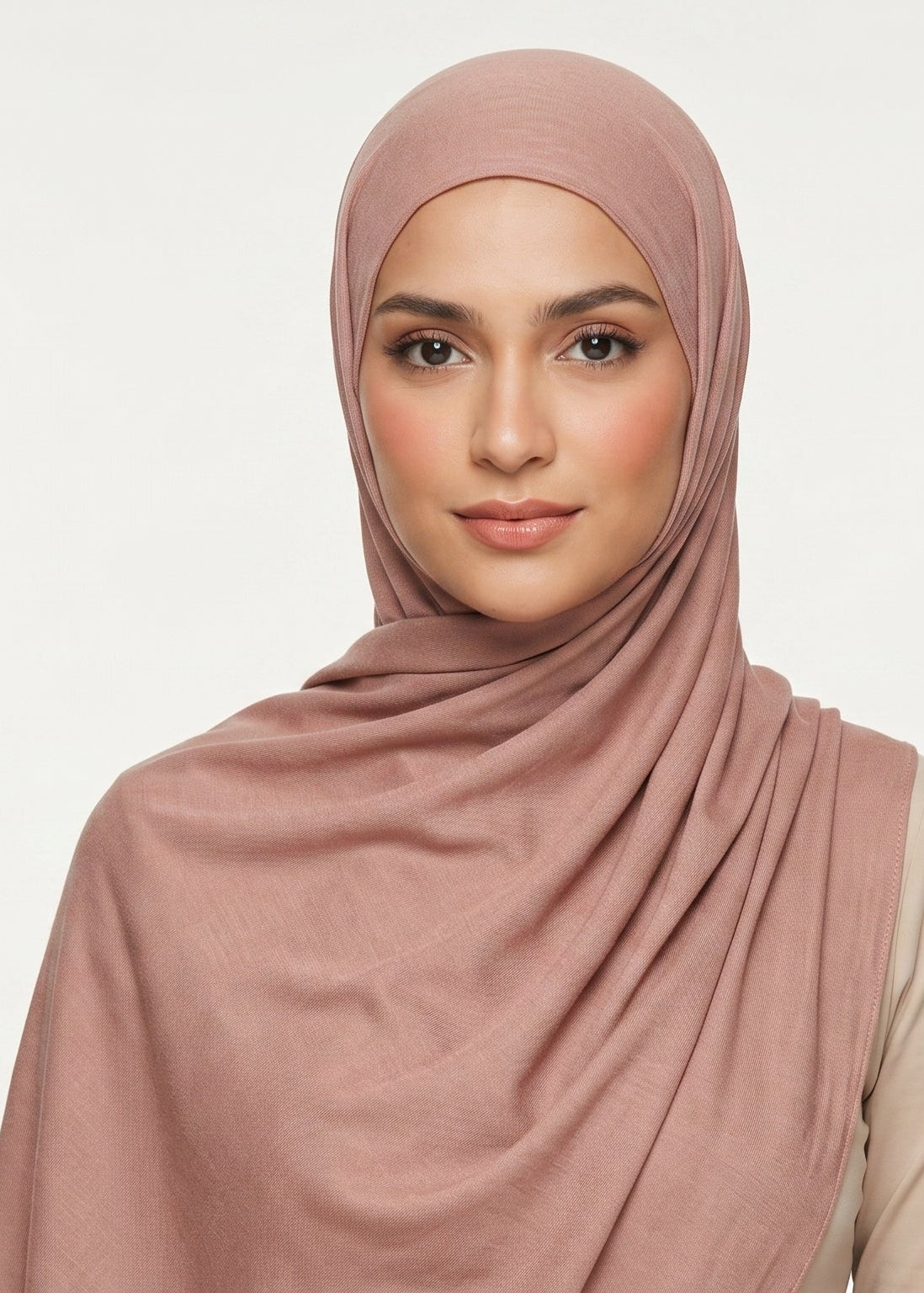 Woman wearing a pink hijab against a white background