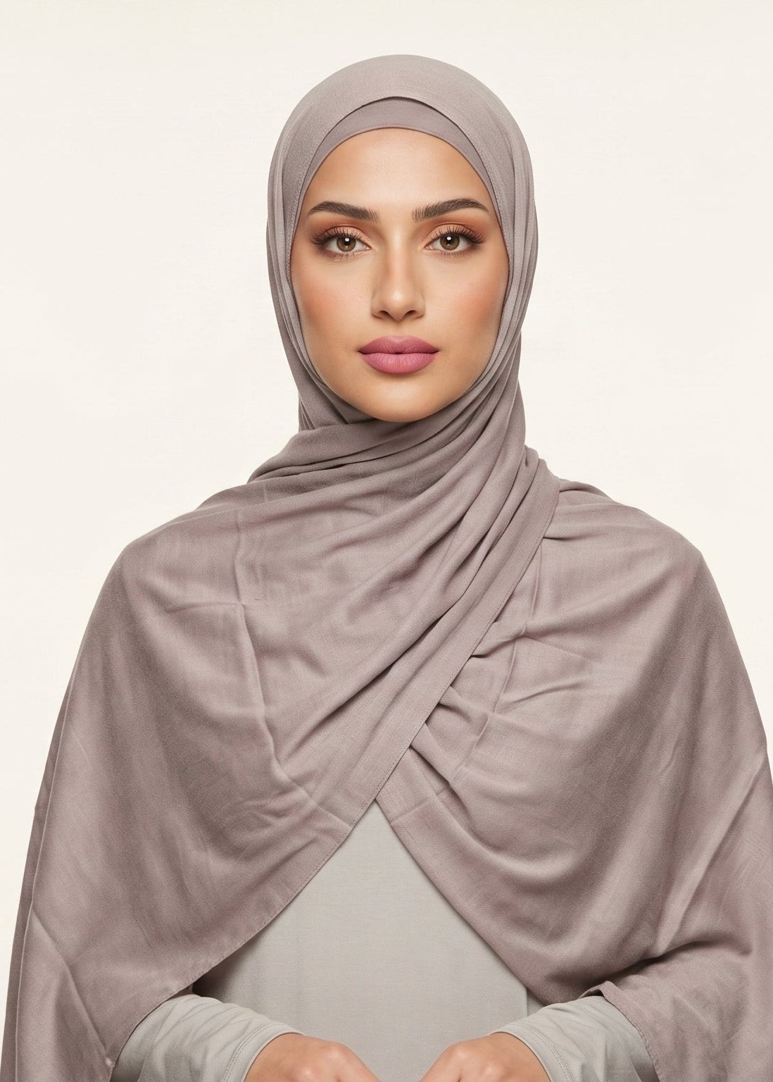 Woman wearing a beige hijab against a light background