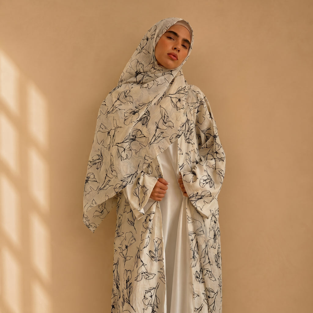 Woman wearing a floral abaya against a beige background